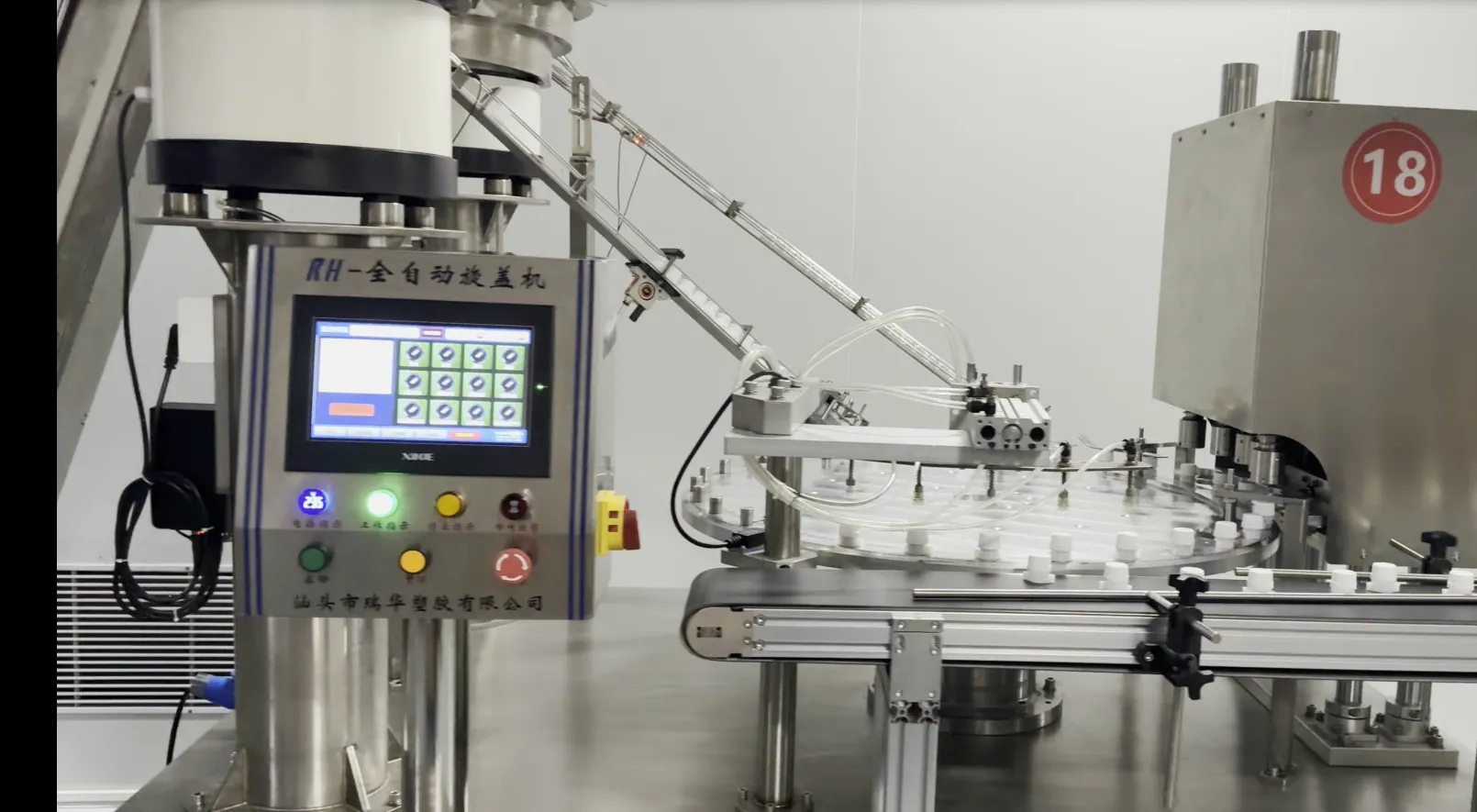 A fully automatic cap seating machine with a touchscreen control panel and a rotary carousel feeding spouted parts through a conveyor