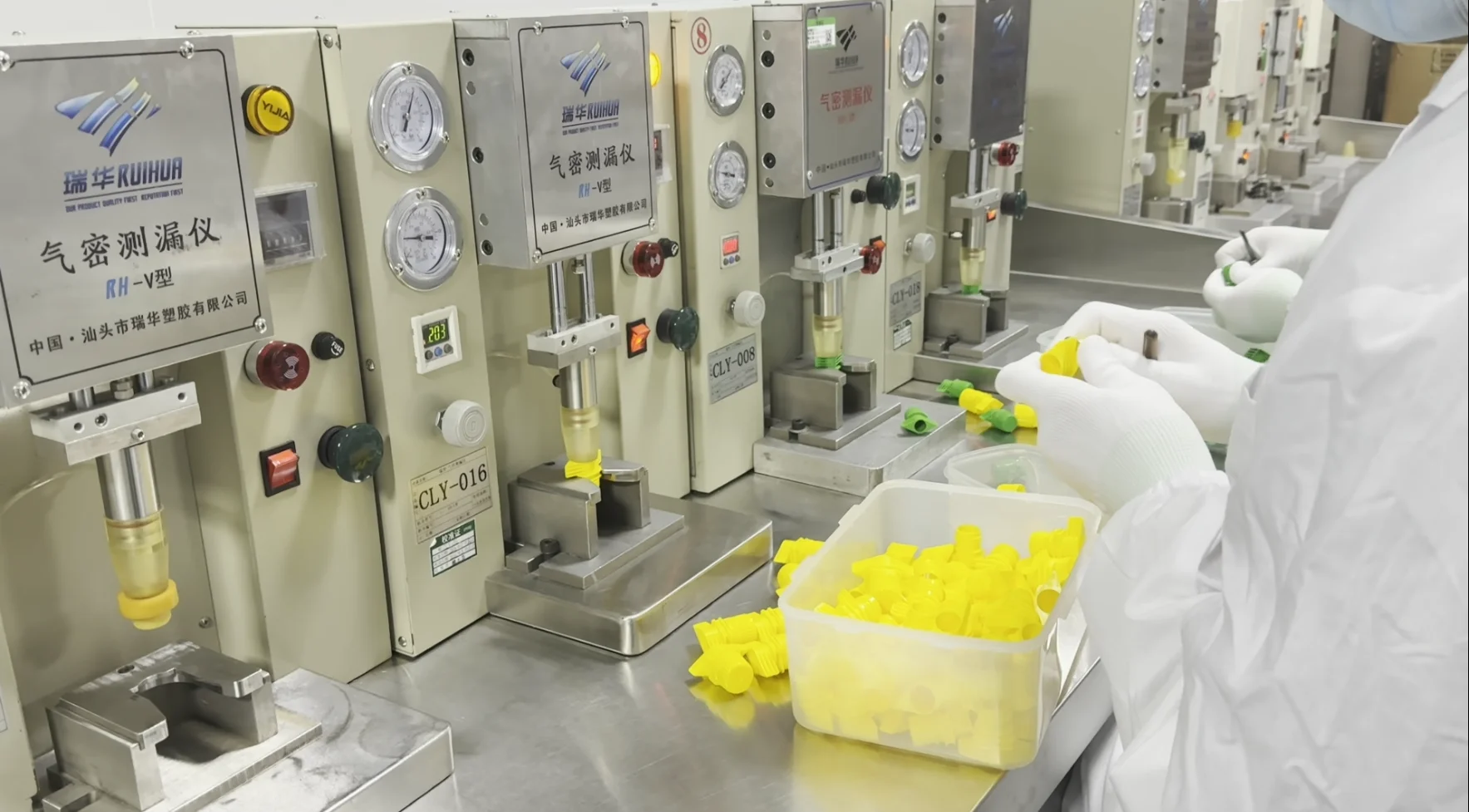 Air-tightness test stations with pressure gauges pressing spout caps in a fixture on the factory inspection bench